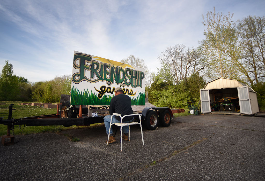 Calvin Miles paints Friendship Baptist's Friendship Garden sign